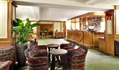 a bar with chairs and a table in a room at Hotel Relais Des Alpes in Madonna di Campiglio