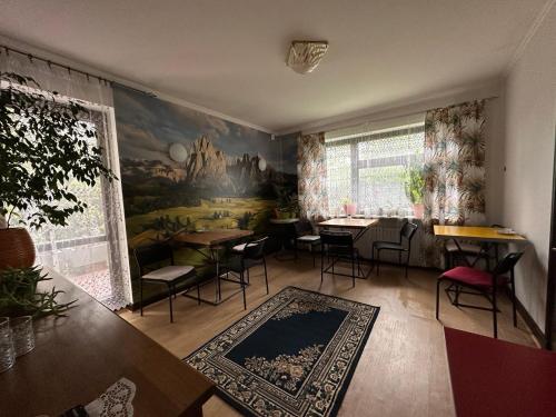 ワルシャワにあるGuest House Villa Arkadiaのテーブルと椅子が備わる壁画のある部屋