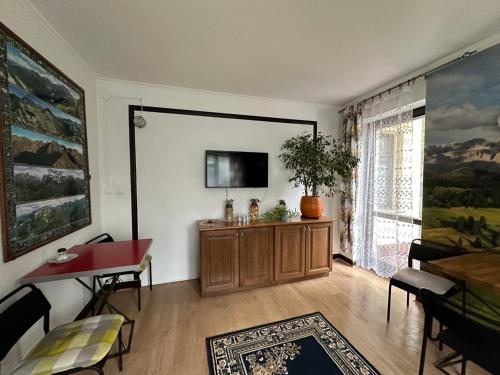 un salon avec une télévision sur un mur et une table dans l'établissement Guest House Villa Arkadia, à Varsovie