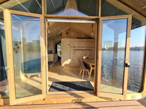 a large glass door of a house with a view of the water at Wikkelboats at Floating Rotterdam Rijnhaven in Rotterdam