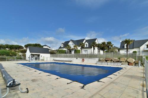 - une piscine dans une cour avec des maisons dans l'établissement La Villa des Marettes - Piscine partagée, à Pléneuf-Val-André