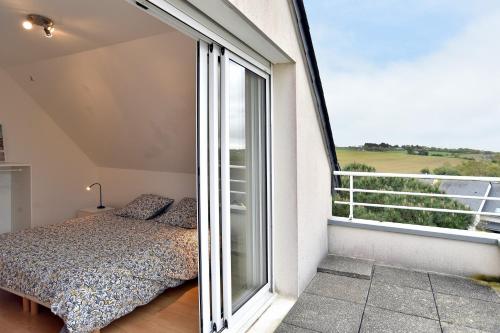 a bedroom with a bed and a large window at La Villa des Marettes - Piscine partagée in Pléneuf-Val-André
