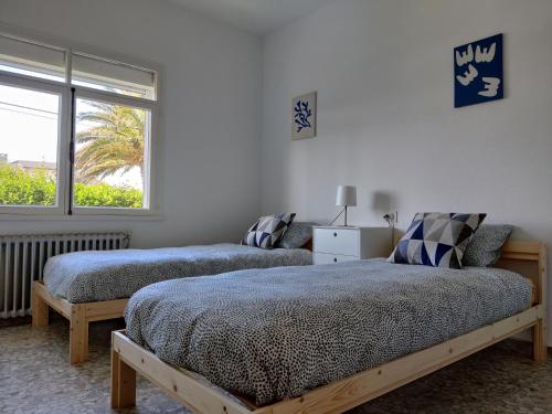 a bedroom with two beds and a window at Casa A Mariña in Barreiros