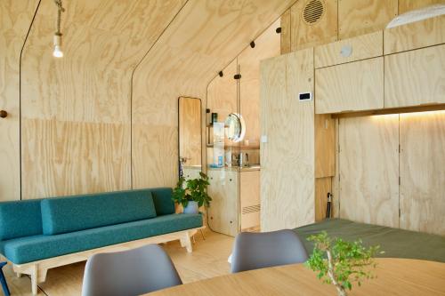 a living room with a blue couch and a table at Wikkelboats at Floating Rotterdam Rijnhaven in Rotterdam