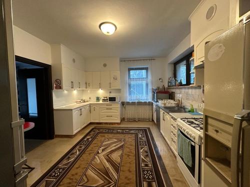 a large kitchen with white cabinets and a stove at Guest House Villa Arkadia in Warsaw