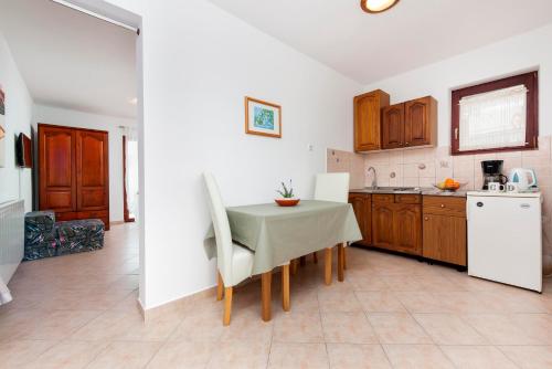 a kitchen with a table and chairs in a room at Apartments and Room Silvana in Rovinj