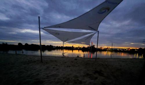 a white kite sitting on the beach near the water at Luxury modern new apartment with garden close to Wroclaw self check-in 24h in Siechnice