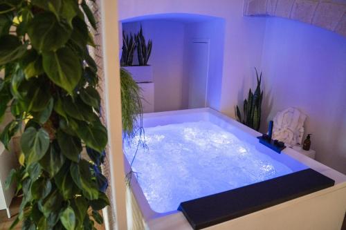 a bathroom with a hot tub with plants in it at Innesto Rooms - Monopoli in Monopoli