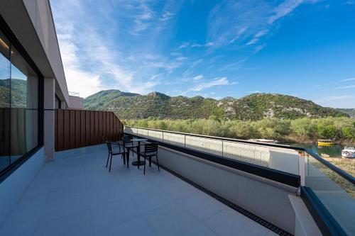 a balcony with chairs and a view of the mountains at Hotel De‘Andros Virpazar in Virpazar