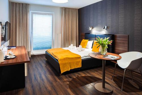 um quarto de hotel com uma cama e uma mesa em Penzion v jízdárně em Olomouc