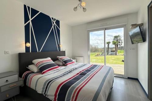 een slaapkamer met een bed en een groot raam bij Cosy Nature in Sainte-Pience