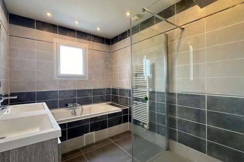 La salle de bains est pourvue d'une baignoire, d'un lavabo et d'une douche. dans l'établissement Cosy Nature, à Sainte-Pience