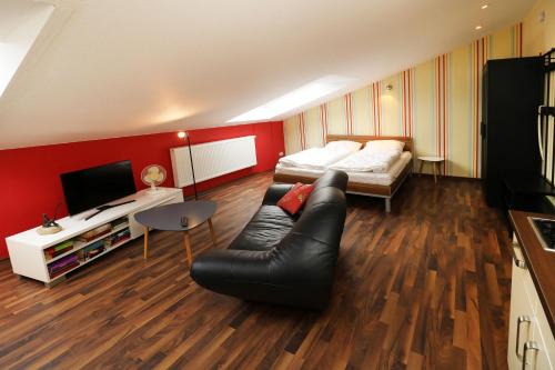 ein Schlafzimmer mit einem Bett, einem Sofa und einem TV in der Unterkunft Ferienhaus Quartier18 strandnah S2 in Ostseebad Karlshagen