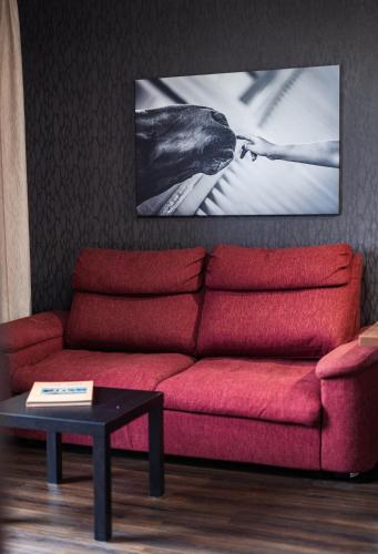 a living room with a red couch and a table at Penzion v jízdárně in Olomouc