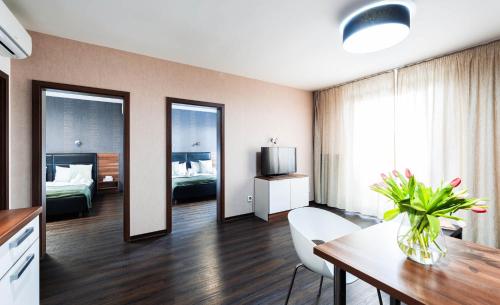a hotel room with a dining table and a bedroom at Penzion v jízdárně in Olomouc