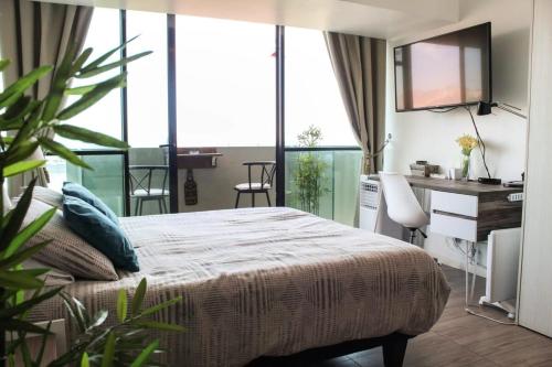 a hotel room with a bed and a desk and a desk at HOM I Depto Estudio con Vista al Mar y Estacionamiento 1016 in Antofagasta