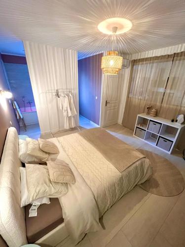 - une grande chambre avec un grand lit et un lustre dans l'établissement Maison d’exception, à Monteux