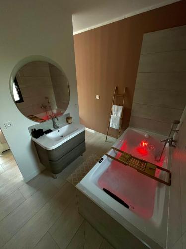 une salle de bain avec une baignoire, un lavabo et un miroir dans l'établissement Maison d’exception, à Monteux