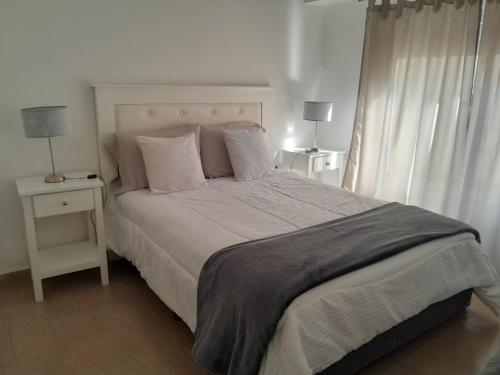 um quarto com uma cama grande, 2 candeeiros e uma janela em Granate em Tandil