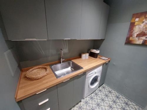 eine Küche mit einer Spüle und einer Waschmaschine in der Unterkunft Green Apartment - City Centre in Genua