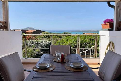 a dining table with chairs and a view of the ocean at Terrazza vista mare Stintino in Stintino