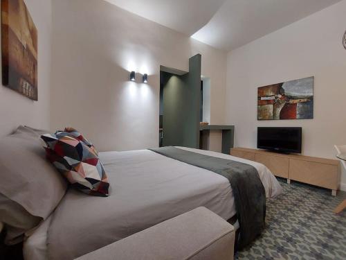 ein Schlafzimmer mit einem großen Bett und einem TV in der Unterkunft Green Apartment - City Centre in Genua