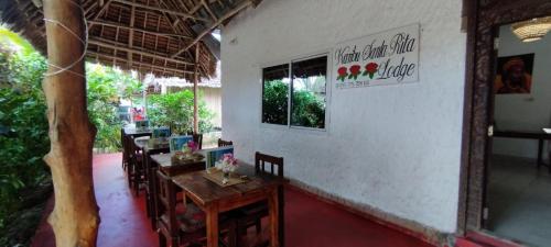 a restaurant with a table and chairs in a room at Santa Rita lodge in Kiwengwa