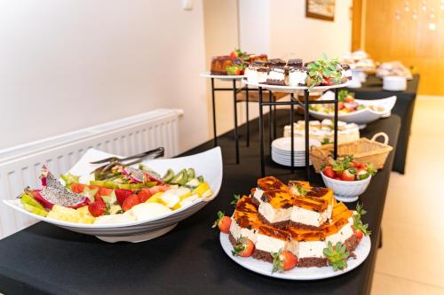 a table topped with plates of food and desserts at Ośrodek Szkoleniowo-Wypoczynkowy "Leśnik" in Ustka