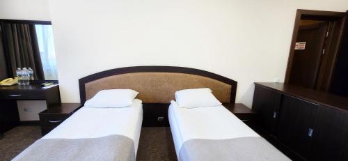 two beds in a hotel room with a headboard at Wellotel Chornomorsk in Chornomorsk