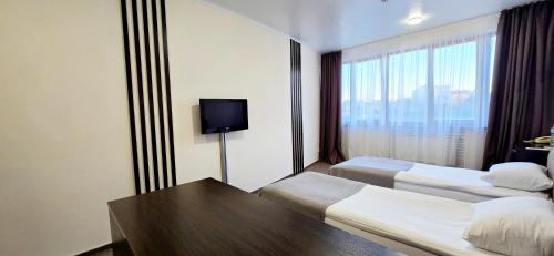 a hotel room with two beds and a table at Wellotel Chornomorsk in Chornomorsk