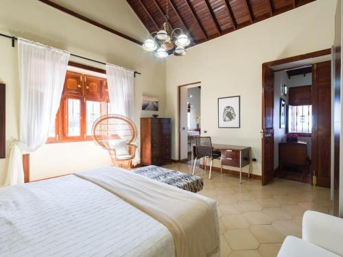 a bedroom with a bed and a chair and a desk at Villa with Pool and sea views in Banana Plantation in Arucas