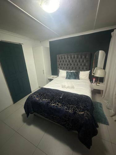 a bedroom with a large bed with a blue wall at The legacy BnB in East London