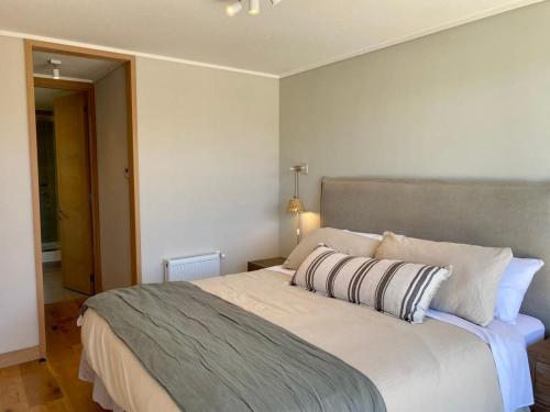 een slaapkamer met een groot wit bed in een kamer bij Comodo Depto, en Puerto Varas Gran Terraza y Parking Servicio HOM in Puerto Varas