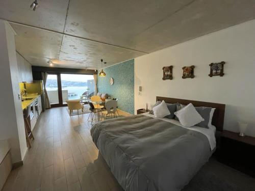 1 Schlafzimmer mit einem großen Bett und einem Esszimmer in der Unterkunft Lujoso Estudio con Mejor Vista del Puerto Parking Servicio HOM 0408 in Valparaíso
