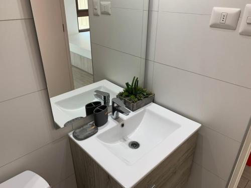 a bathroom with a white sink and a mirror at HOM I Lujoso Estudio con Mejor Vista del Puerto Parking 0408 in Valparaíso