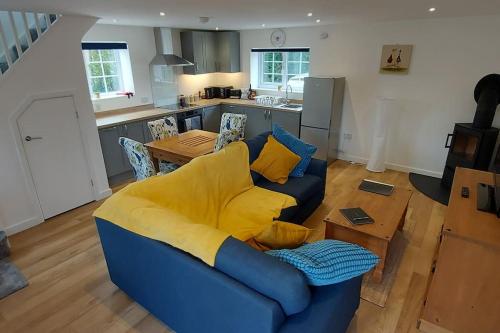 a blue couch with yellow pillows in a living room at Pond Puddle at Pond Pool Cottage in Taunton