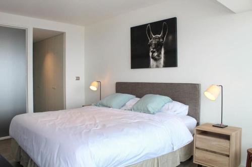 1 dormitorio con 1 cama con una foto de un ciervo en la pared en Espectacular Depto 1D1B, y Estacionamiento Privado Servicio HOM, en Antofagasta