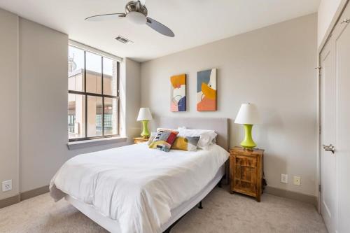 a white bedroom with a bed and a window at 2BR Luxury Apartment With Rooftop Deck & Pool in Baltimore