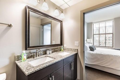 a bathroom with two sinks and a large mirror at 2BR Luxury Apartment With Rooftop Deck & Pool in Baltimore