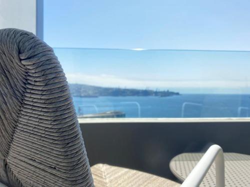 ein Rattanstuhl vor einem Fenster in der Unterkunft HOM I EnValparaiso, Loft Ubicado en MiradorBarón Parking 1613 in Valparaíso