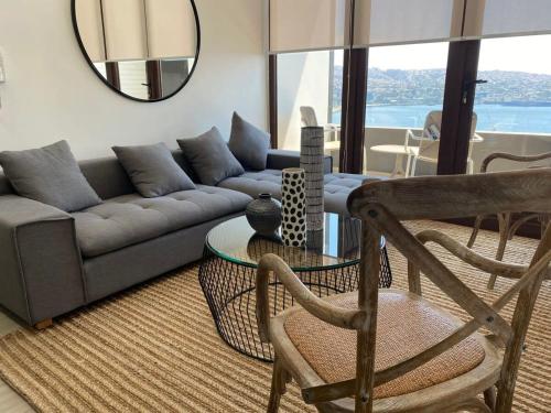 ein Wohnzimmer mit einem Sofa, einem Tisch und einem Spiegel in der Unterkunft HOM I EnValparaiso, Loft Ubicado en MiradorBarón Parking 1613 in Valparaíso