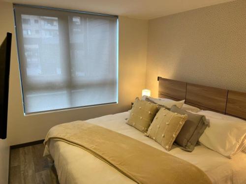 um quarto com uma cama e uma janela grande em Familiar Depto con Estacionamiento y Gran Terraza em Puerto Varas