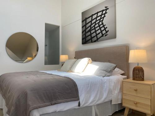 1 dormitorio con 1 cama grande y espejo en Amplio Loft con MejorVista al Puerto de Valparaiso Servicio HOM 1413, en Valparaíso