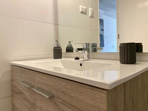 a bathroom with a white sink and a mirror at HOM I TOP1 Amplio Loft con Jardín Nuevo Estacionamiento 1309 in Valparaíso