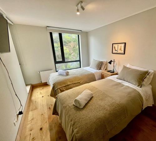 1 dormitorio con 2 camas y ventana en Hermoso Depto 4PAX en Mejor Ubicación de PtoVaras Servicio HOM, en Puerto Varas