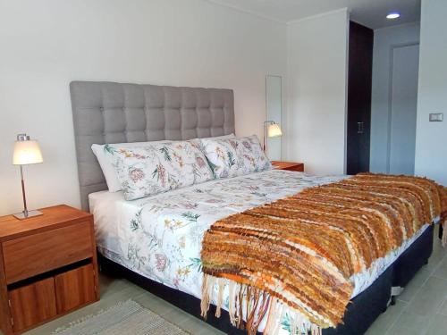a bedroom with a bed and a nightstand and a bed sidx sidx at Mejor Ubicación de Puerto Varas con Estacionamiento Servicio HOM in Puerto Varas