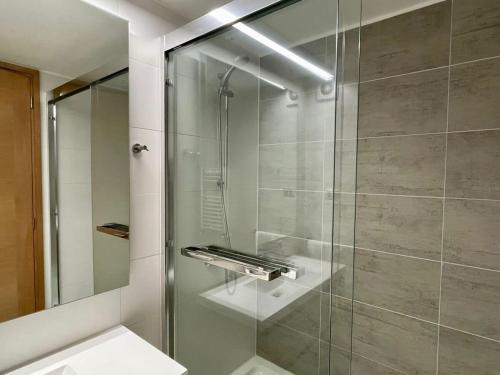 baño con ducha y puerta de cristal en Hermoso Depto 4PAX en Mejor Ubicación de PtoVaras Servicio HOM, en Puerto Varas