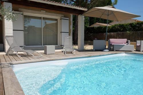 une piscine avec des chaises et un parasol dans l'établissement Le Vieil Olivier 2, à Cornillon