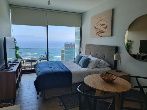 a bedroom with a bed and a view of the ocean at HOM I Hermoso Estudio, Estacionamiento PNB 2017 in Antofagasta