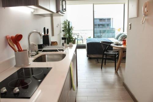 una cucina con lavandino e una camera con letto di HOM I Departamento Estudio en Mejor Zona Frente al Mall 1218 ad Antofagasta